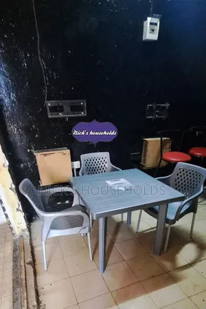A Square Plastic Table With 3 Plastic Chairs With Metal Legs