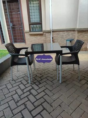 2 Plastic Chairs With a Plastic Table