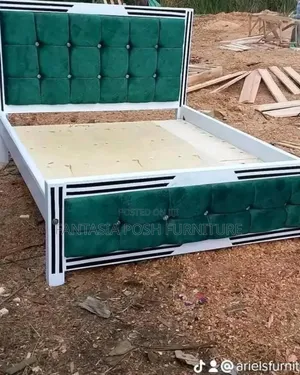 White Wooden Bed With Green Upholstered Button Tufted Panels.