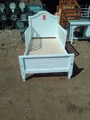 White Wooden Kids Bed With Safety Rails And Decorative Headboard