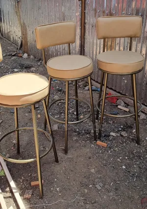 Powder-Coated Metal Bar Stool With Beige Upholstery.
