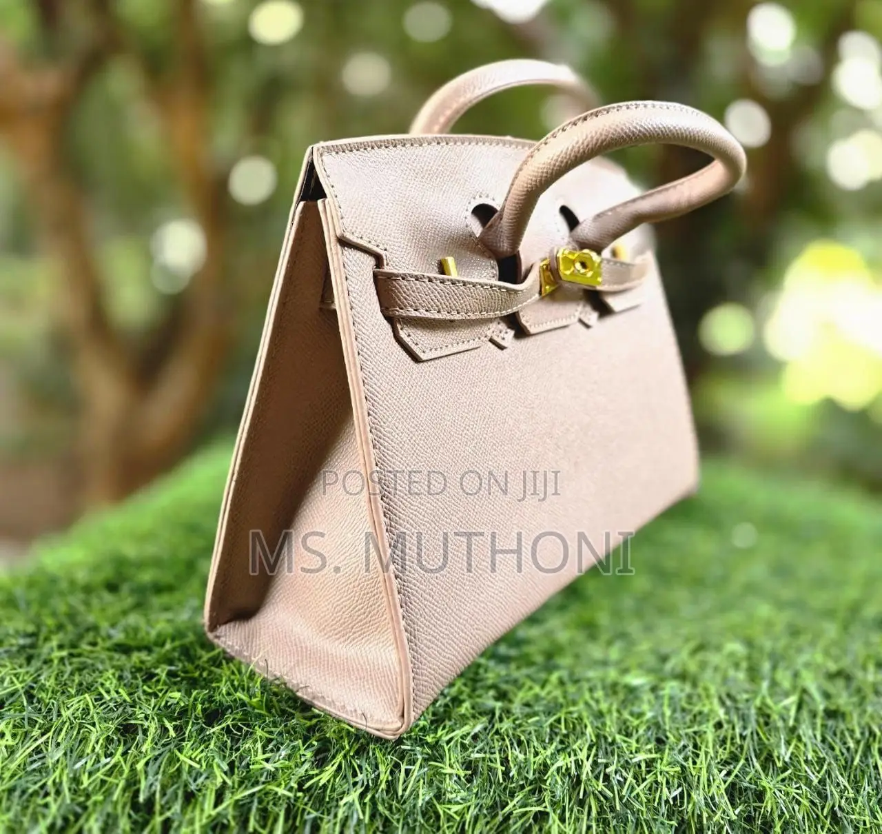 Textured Birkin Bag With an Adjustable Strap and Button Closure.