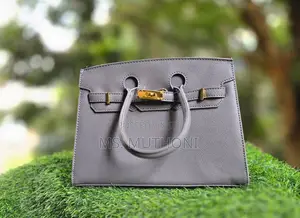 Textured Birkin Bag With an Adjustable Strap and Button Closure.