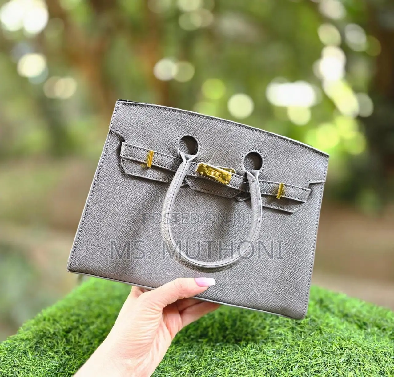 Textured Birkin Bag With an Adjustable Strap and Button Closure.