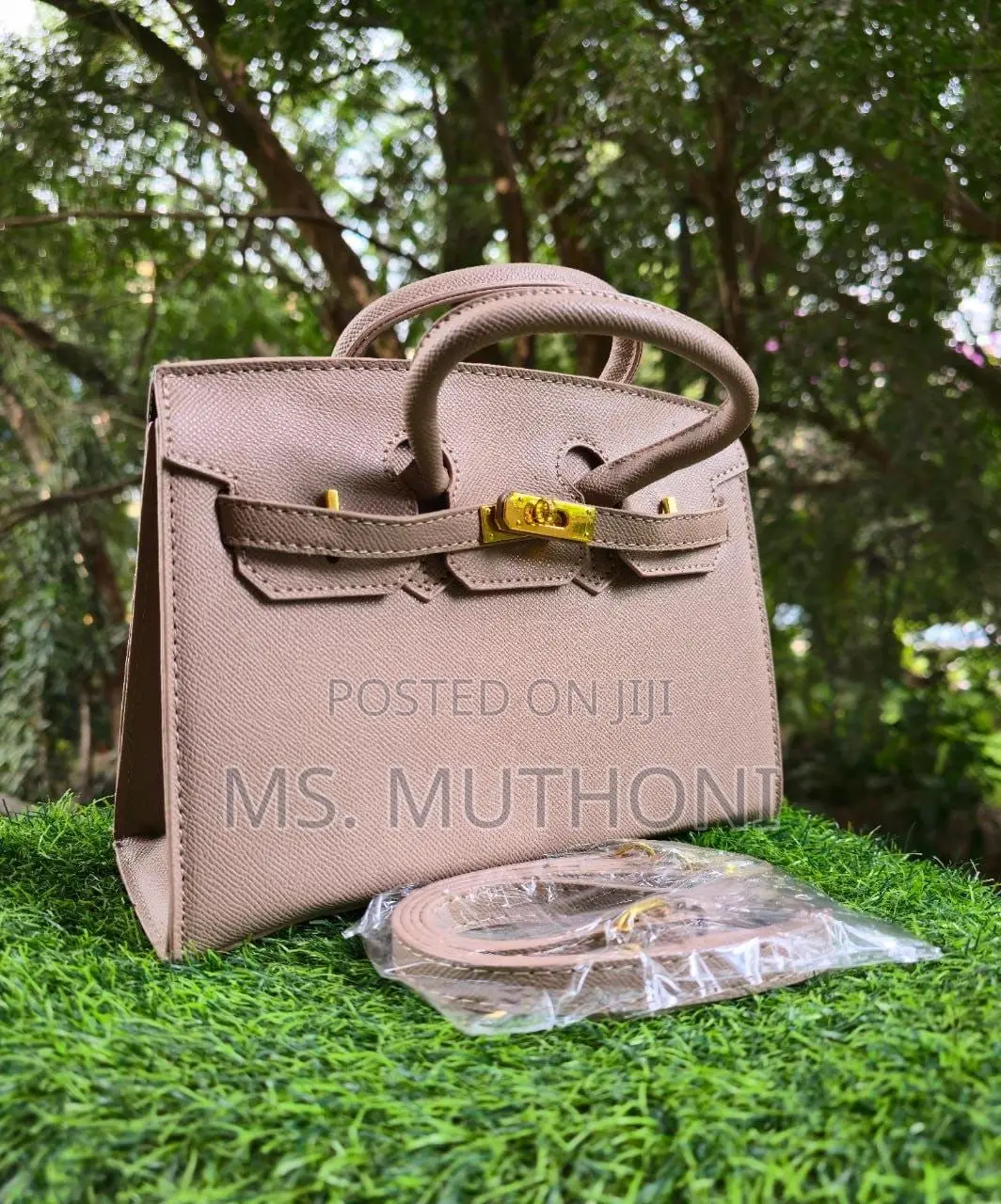Textured Birkin Bag With an Adjustable Strap and Button Closure.