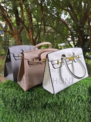 Textured Birkin Bag With an Adjustable Strap and Button Closure.