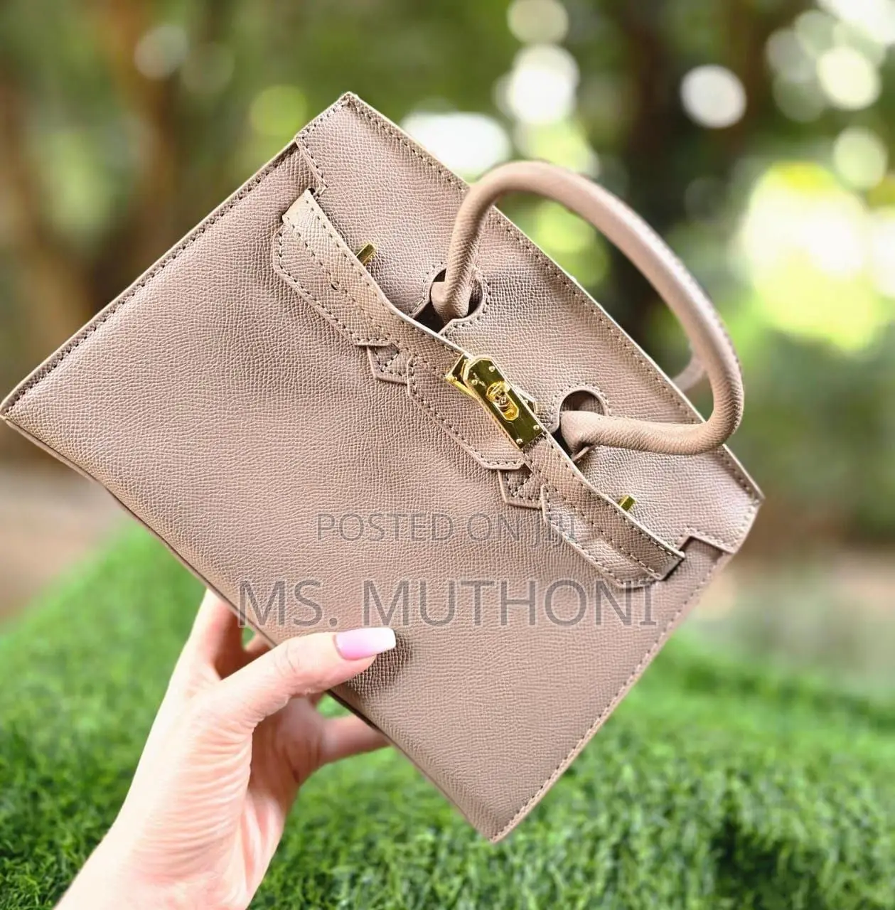 Textured Birkin Bag With an Adjustable Strap and Button Closure.