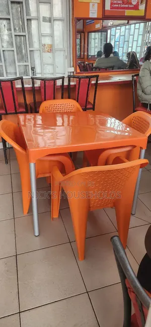 Orange Plastic Chairs and a Square Plastic Table With Metal Legs