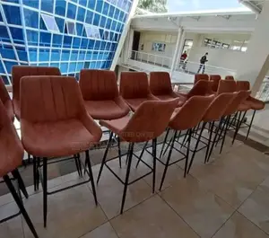 Modern Bar Stool Featuring Upholstered Brown Seat and Black Metal Legs