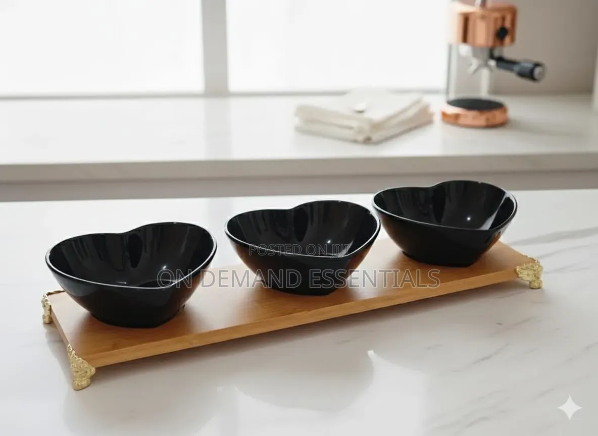 Three Heart-Shaped Black Ceramic Bowls on a Bamboo Tray