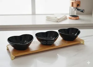 Three Heart-Shaped Black Ceramic Bowls on a Bamboo Tray