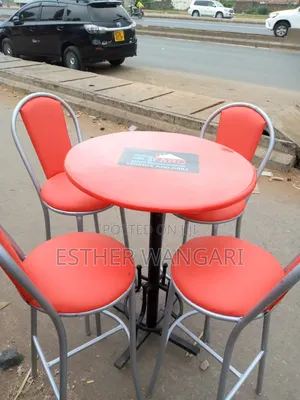 A Set of Red Painted Silver Hotel Chairs and a Table