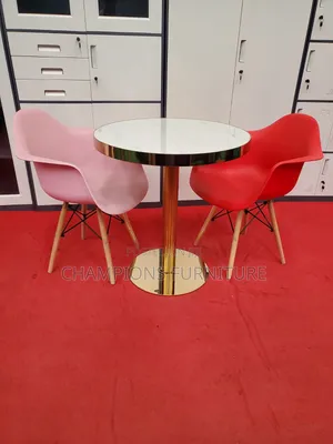 Gold Pedestal Table With Molded Shell Armchairs