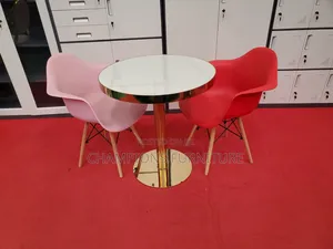 Gold Pedestal Table With Molded Shell Armchairs